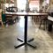 Wooden table with black metal base in a store setting