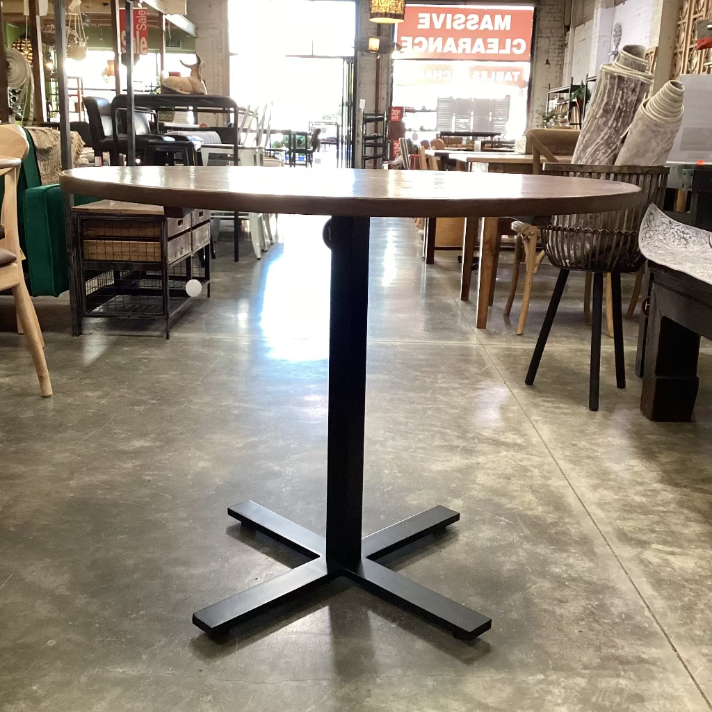 Wooden table with black metal base in a store setting