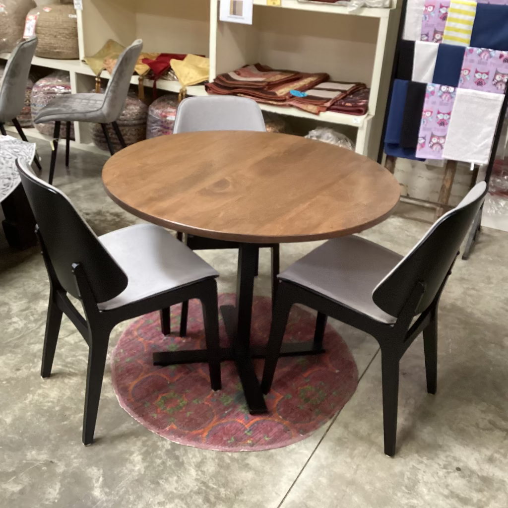 Round wooden table with four chairs in a store setting